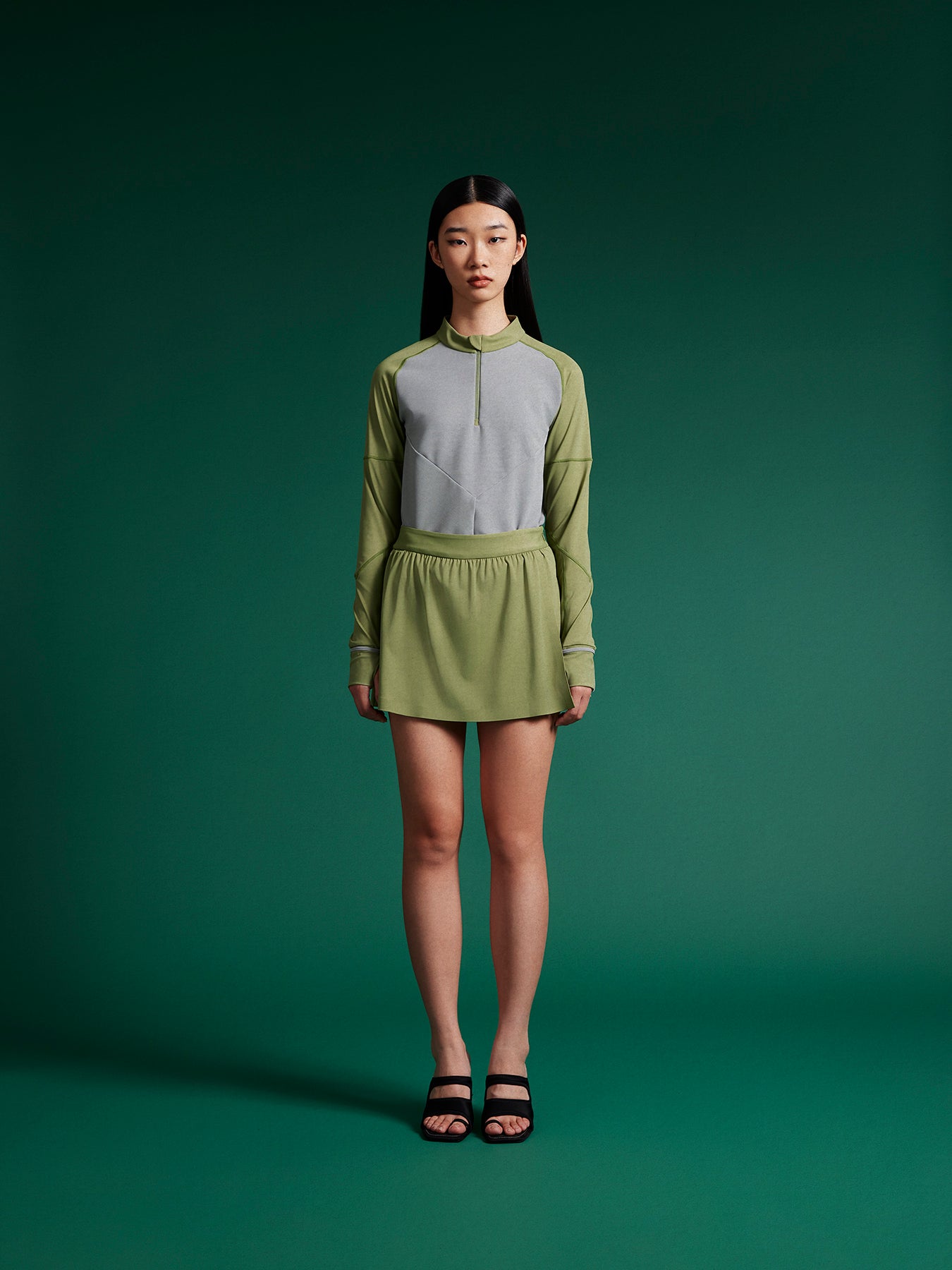 model wear mini green skirt with grey tops
